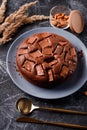 Chocolate cake with chocolate pieces on a metallic black background