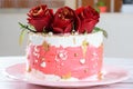 Chocolate cake covered with Swiss meringue buttercream, with three red flowers on top side view