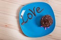 Chocolate cake with creamy cream on a blue plate, with a chocolate inscription love.