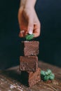 Chocolate cake cut with squares on a black background with hand Royalty Free Stock Photo