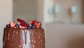 Appetizing chocolate cake decorated with strawberries, blueberries and a pomegranate on an orange background Royalty Free Stock Photo