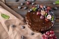 Chocolate cake with fresh berries red grapes and blueberries, mint on a beige towel on a wooden brown background, berry pie, Royalty Free Stock Photo