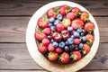 Chocolate cake with fresh summer berries, strawberries, raspberries, blueberries and cherries. Rustic wooden background Royalty Free Stock Photo