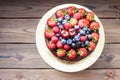Chocolate cake with fresh summer berries, strawberries, raspberries, blueberries and cherries. Rustic wooden background Royalty Free Stock Photo