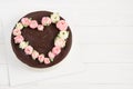 Chocolate cake with heart of pink  roses, white background, wooden board Royalty Free Stock Photo