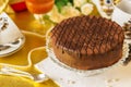 Chocolate cake on large platter, cups, saucers and spoons for tea