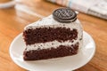 Chocolate Cake with oreo and whipped cream on white plate and wood table has ready to served.