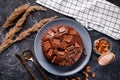 Chocolate cake with chocolate pieces on a metallic black background