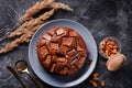 Chocolate cake with chocolate pieces on a metallic black background