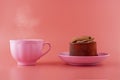 chocolate cake on a pink saucer with a pink cup on a pink background