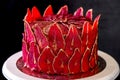 Chocolate cake with sliced red pears with gold, like a crown on the black background close-up. Royalty Free Stock Photo