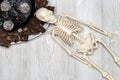 Chocolate cake and slices on a plate and skeleton on a wooden table. Concept of death from diabetes