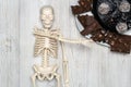 Chocolate cake and slices on a plate and skeleton on a wooden table. Concept of death from diabetes