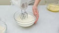 Chocolate cake step by step recipe. Woman hands beating egg whites with mixer, close up view Royalty Free Stock Photo