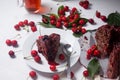 Chocolate cake with sweet cherry, cup of tea and bouquet of blue flowers on white background Royalty Free Stock Photo