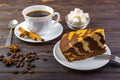 A chocolate cake on a white plate with a fork and a cup of black tea. A tea spoon. anise, coffee beans and a bowl of sugar cubes o Royalty Free Stock Photo