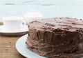 Chocolate cake whole close up on blue plate with rustic wood background Royalty Free Stock Photo