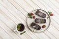 Chocolate cakes with strawberry filling on a flat plate with a cup of tea on a white wooden background Royalty Free Stock Photo