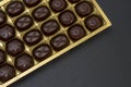 chocolate candies in a box on a black background. dark photo