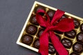 chocolate candies in a box with a red bow