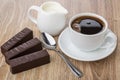 Chocolate candies, coffee in cup, spoon and jug of milk Royalty Free Stock Photo