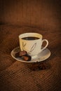 Chocolate candies and cup of hot coffee on wooden background Royalty Free Stock Photo