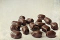 Chocolate candies. Dark chocolates with natural plum filling. Old paper textured image