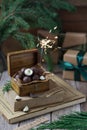 Chocolate candies in wooden box with bengal light and christmas decoration