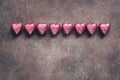 Chocolate candy heart in a pink wrapper on vintage dark background. Beautiful festive background Valentine`s Day