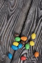 Chocolate candy in multi-colored glaze. Scattered on black pine boards Royalty Free Stock Photo