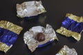 Chocolate candy in an unfolded wrapper on the table