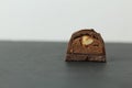 Chocolate candy with whole walnut forest hazelnuts with praline chocolate filling in section on a dark black background with space