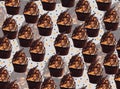 Chocolate Caramel cupcake with chocolate shaves on frosting pattern on light background with polka dots