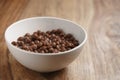 Chocolate cereal balls with milk in white bowl for breakfast on wooden table Royalty Free Stock Photo