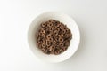 Chocolate cereal rings falling in bowl isolated on white background, top view Royalty Free Stock Photo