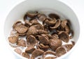 Chocolate cereals with fresh milk in white bowl background. Delicious cocoa cornflake
