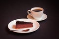 Chocolate cheesecake with chocolate sauce and cup of black coffee. Selective focus on cheesecake Royalty Free Stock Photo