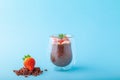 Chocolate Chia pudding decorated with strawberry on blue background Royalty Free Stock Photo