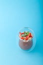 Chocolate Chia pudding decorated with strawberry on blue background Royalty Free Stock Photo