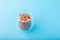 Chocolate Chia pudding decorated with strawberry on blue background Royalty Free Stock Photo
