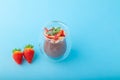 Chocolate Chia pudding decorated with strawberry on blue background Royalty Free Stock Photo