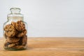 Chocolate chip cookie in a glass jar on a wooden table. White background with copy space Royalty Free Stock Photo