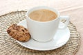 Chocolate chip cookie on saucer with coffee