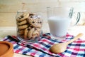 Chocolate chip cookies in glass jars with milk on wooden background Royalty Free Stock Photo