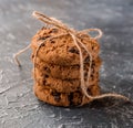 Chocolate chip cookies stacked and tied with a cord on a textured background