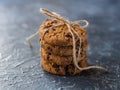 Chocolate chip cookies stacked tied with a cord, on a textured background