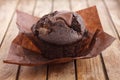 Chocolate chip muffin in brown wax paper. Unwrapped