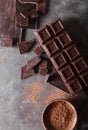 Chocolate chunks and cocoa powder. Chocolate bar pieces. A large bar of chocolate on gray abstract background. Background with c Royalty Free Stock Photo