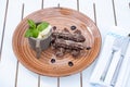 Chocolate churros with ice cream on a brown porcelain plate