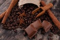 Chocolate, cinnamon sticks  and coffee beans on wooden background Royalty Free Stock Photo